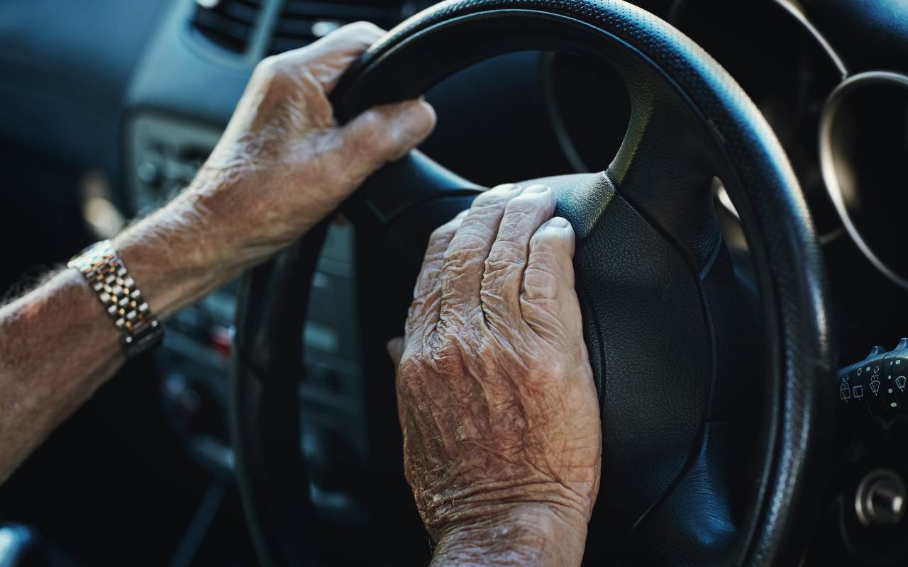 Mani di un anziano al volante