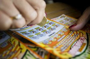persona che gratta un Gratta e Vinci